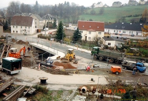 18. November 1996. Die neue Doktorbrücke ist fast fertig gestellt. Zum Zeitpunkt wurde der Verkehr einspurig durch Ampel geregelt, aber bereits über die neue Brücke geführt. Zahlreiche Restarbeiten werden erledigt. Im Vordergrund wird der Anschluss-Zipfel zu den Grundstücken Hauptstraße 61, 63 und 65 hergerichtet. Die Behelfsbrücke wird abgerissen.